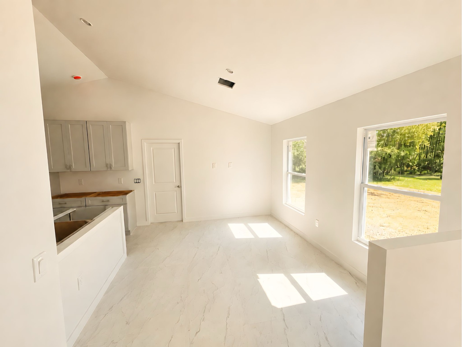 Great room of The Egret under construction &mdash; vaulted ceiling and porcelain tile
